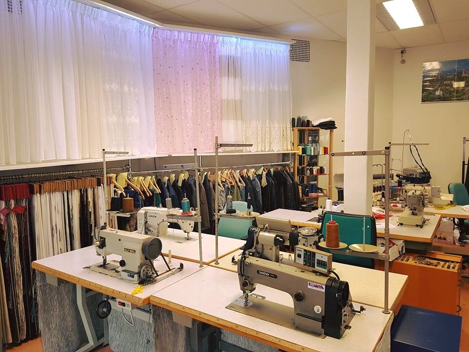 Het atelier met industriële naaimachines en kledingrekken